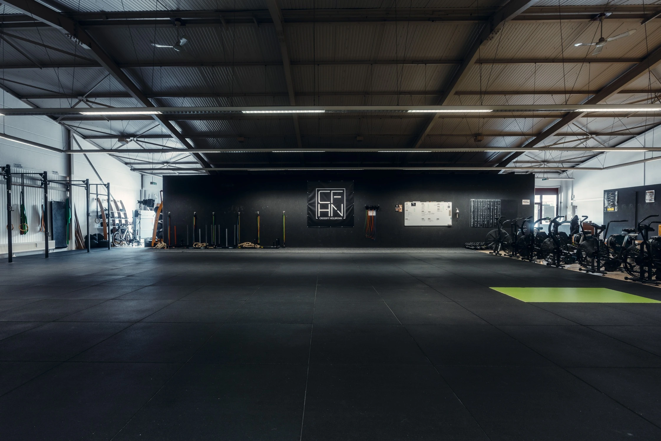 Eine geräumige CrossFit-Box in Heilbronn mit funktionalem Trainingsequipment und Airbikes.
