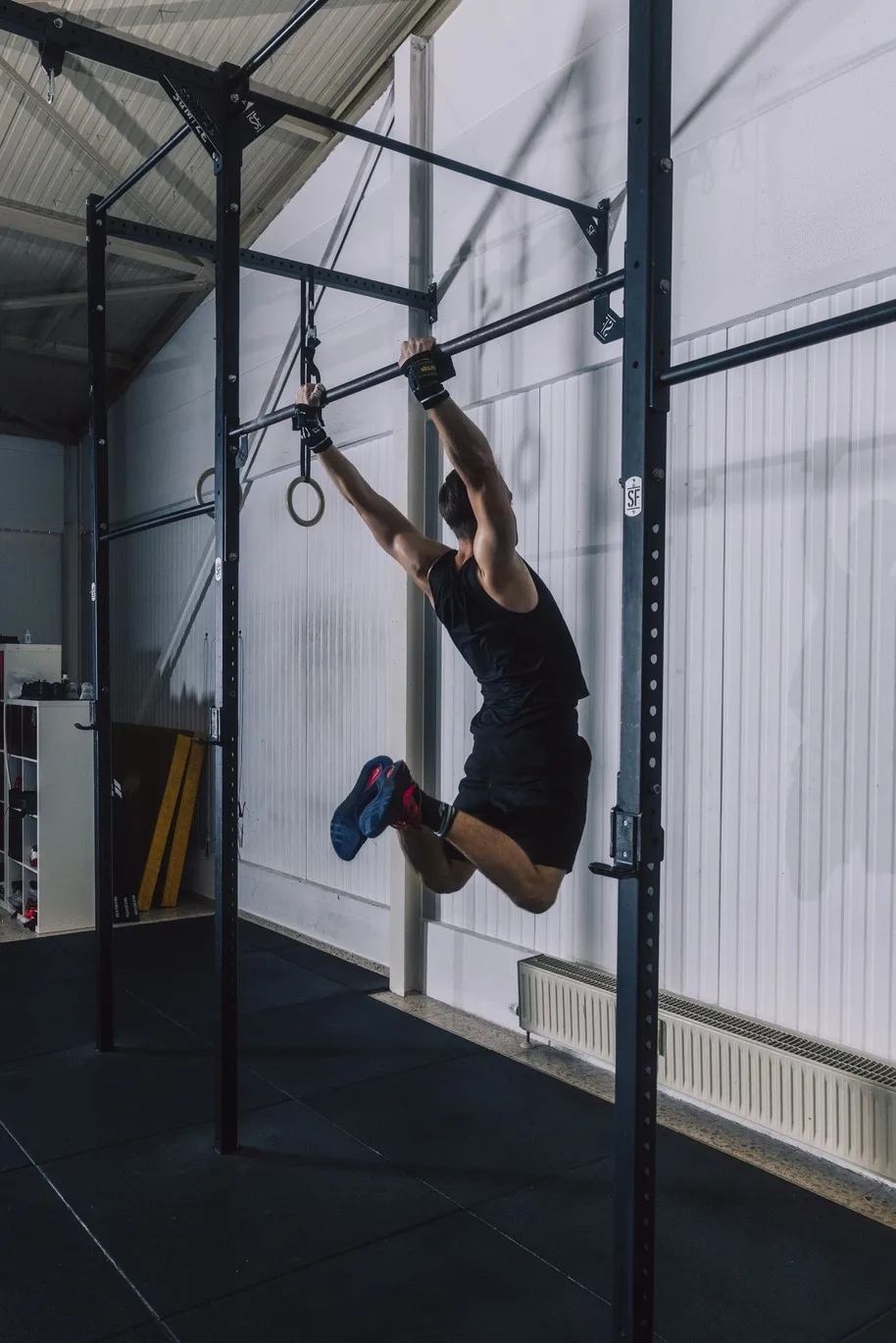 Ein Athlet führt in einer CrossFit-Box einen Klimmzug an einer Pull-up-Bar aus.